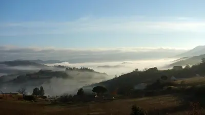 a view of a valley with fog in the hills at Gîte Vigneron du Domaine d'Alon in Magrie