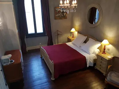 a bedroom with a bed and two lamps and a mirror at Villa Limonade, maison d'hotes in Olonzac