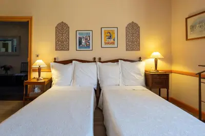 two beds in a hotel room with two lamps at Villa Limonade, maison d'hotes in Olonzac