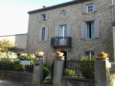 a stone house with a gate and a fence at La Belle Minervoise in Saint-Frichoux