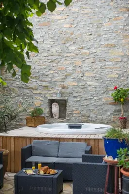 a stone wall with a bath tub in a patio at La Belle Minervoise in Saint-Frichoux