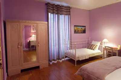 a bedroom with purple walls and a bed and a mirror at La Belle Minervoise in Saint-Frichoux