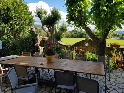 a wooden table and chairs in a garden at La Belle Minervoise in Saint-Frichoux