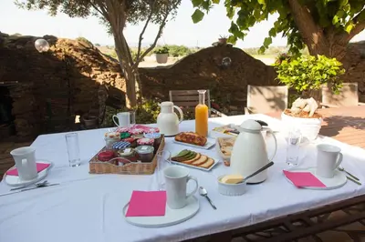 a table with a white table cloth with food on it at La Belle Minervoise in Saint-Frichoux