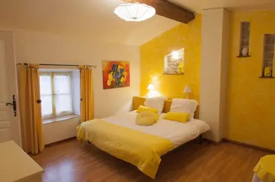 a bedroom with yellow walls and a bed with yellow pillows at La Belle Minervoise in Saint-Frichoux