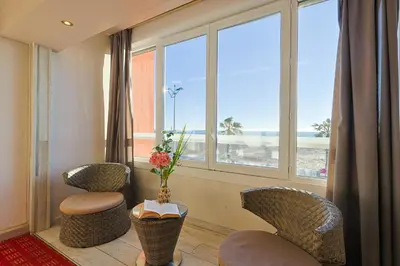 a dining room with white tables and chairs at Logis Hôtel & Restaurant Mediterranee in Port-la-Nouvelle