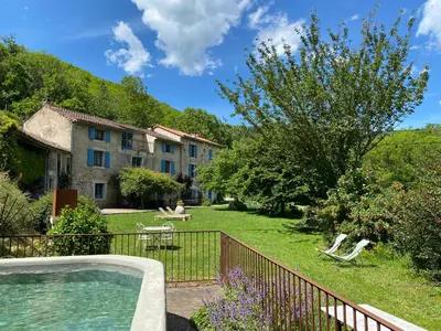 a yard with a house and a swimming pool at Nabat le Haut, chambre et table d'hotes in Courniou