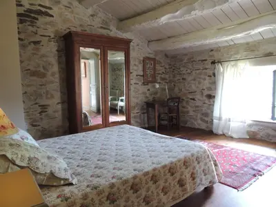 a bedroom with a large bed and a window at Nabat le Haut, chambre et table d'hotes in Courniou
