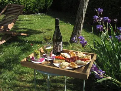 a bottle of wine and a tray of food and wine glasses at Logis Hôtel Château De Palaja in Carcassonne