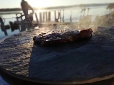 a piece of meat is cooking on a table at Maison de pecheur in Sigean