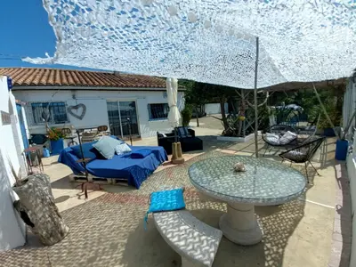 a patio with a table and chairs and an umbrella at Maison de pecheur in Sigean