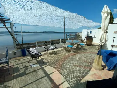 a patio with a table and chairs and an umbrella at Maison de pecheur in Sigean