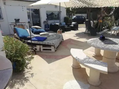 a patio with a bed and an umbrella at Maison de pecheur in Sigean