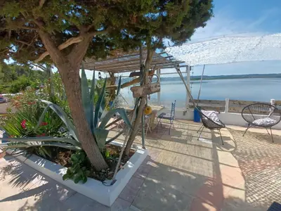 a gazebo with a tree and a table and chairs at Maison de pecheur in Sigean