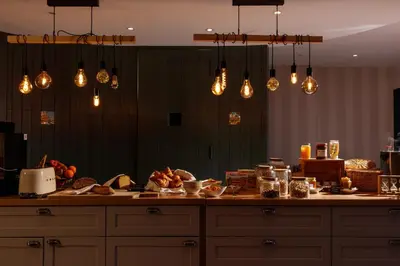 a kitchen with a counter with lots of food and lights at Auberge du Poids Public Logis Hotel in Saint-Félix-Lauragais