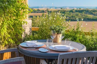 a table with plates and wine glasses on it at Auberge du Poids Public Logis Hotel in Saint-Félix-Lauragais