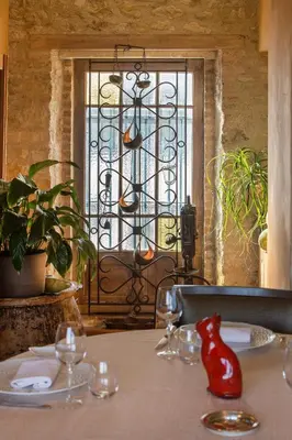 a table with wine glasses and a window at Auberge du Poids Public Logis Hotel in Saint-Félix-Lauragais