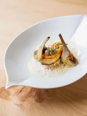 a white plate with some food on a table at Auberge du Poids Public Logis Hotel in Saint-Félix-Lauragais