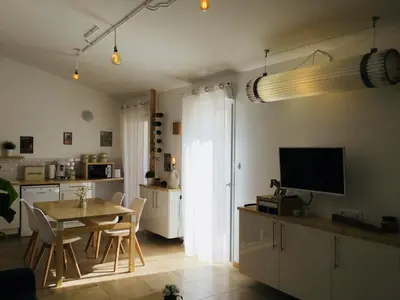 a kitchen and dining room with a table and a television at Gite Blanco y Madera in Narbonne