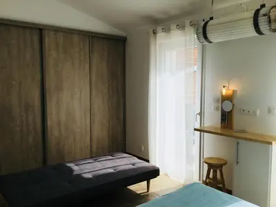 a bedroom with a bed and a large window at Gite Blanco y Madera in Narbonne