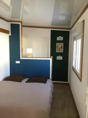 a bedroom with a bed and a blue wall at Gite Blanco y Madera in Narbonne