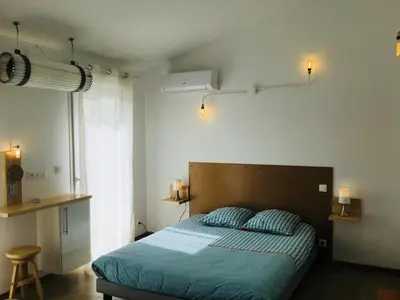 a bedroom with a bed with a blue comforter at Gite Blanco y Madera in Narbonne