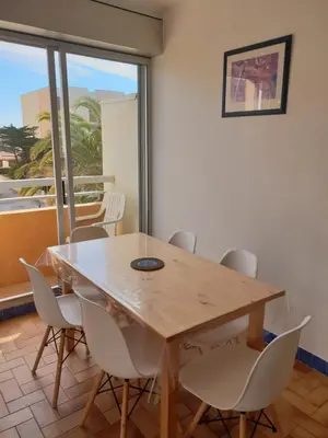 a dining room with a wooden table and chairs at Gites de France Bleu à la mer in Port-la-Nouvelle