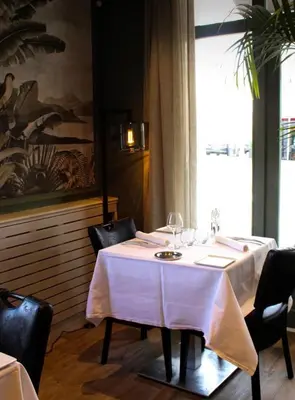 a table in a restaurant with a white table cloth at Hotel Restaurant du Centre et du Lauragais in Castelnaudary