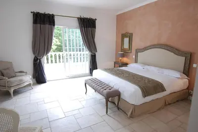 a bedroom with a bed and a chair and a window at Château de Floure - SPA et piscine extérieure chauffée in Carcassonne