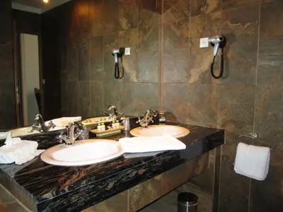 a bathroom with two sinks and a large mirror at Château de Floure - SPA et piscine extérieure chauffée in Carcassonne