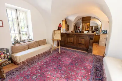 a living room with a couch and a kitchen at Château de Floure - SPA et piscine extérieure chauffée in Carcassonne