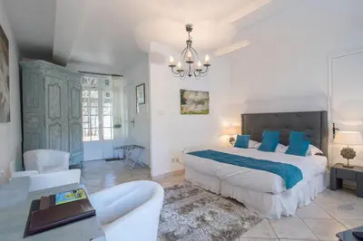 a bedroom with a large bed and a couch at Château de Floure - SPA et piscine extérieure chauffée in Carcassonne