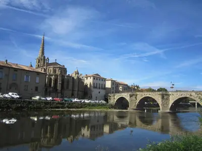a bridge over a river with buildings and a church at Hotel Moderne Et Pigeon in Limoux