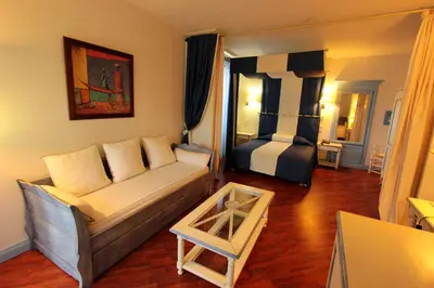 a living room with a couch and a bed at Hotel Moderne Et Pigeon in Limoux