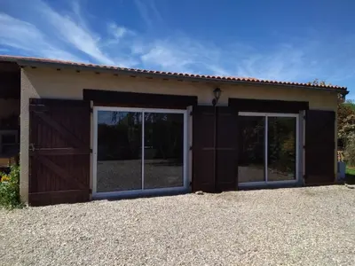 a garage with two sliding doors and a building at loft At Besset in Besset