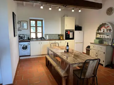 a kitchen with a table with a bottle of wine on it at Domaine Saladry in Villepinte
