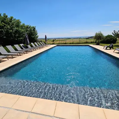 a swimming pool with lounge chairs and a swimming pool at Domaine Saladry in Villepinte