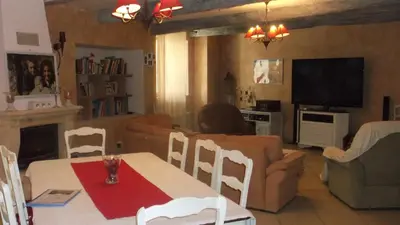 a living room with a table and a couch at La Grange d'Antan in Cruzy