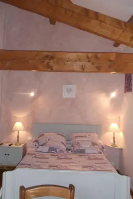 a bedroom with a bed and two lamps on tables at La Grange d'Antan in Cruzy