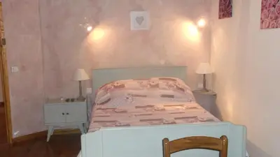 a small bedroom with a bed and a chair at La Grange d'Antan in Cruzy