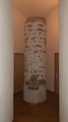 a stone pillar in the middle of a room at La Grange d'Antan in Cruzy