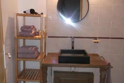 a bathroom with a sink and a mirror and towels at La Grange d'Antan in Cruzy