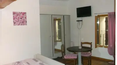 a room with a table and a small table and chair at La Grange d'Antan in Cruzy