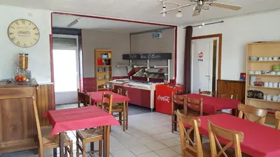 a restaurant with red tables and chairs and a kitchen at Hotel Ô Fil de L'ô in Marseillette
