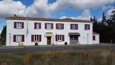 a white building with red shutters on a street at Hotel Ô Fil de L'ô in Marseillette