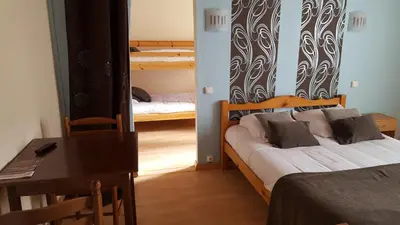 a room with two bunk beds and a table and a desk at Hotel Ô Fil de L'ô in Marseillette