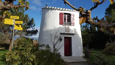a small white building with a red door and a window at Hotel Ô Fil de L'ô in Marseillette