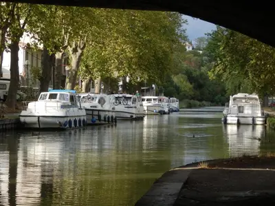 a group of boats are docked in a river at The Railway Cottage at Montazels in Espéraza
