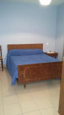a bedroom with a large bed with a wooden headboard at La Nappie in Réalmont