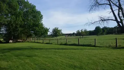 a fence in the middle of a grass field at La Nappie in Réalmont